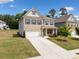 Inviting two-story home showcasing a mix of brick and siding, a neat lawn, and an attached two-car garage at 3360 Meadow Grass Dr, Dacula, GA 30019