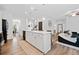 Spacious kitchen features a large island with seating, hardwood floors, and an open layout to the living area at 3360 Meadow Grass Dr, Dacula, GA 30019