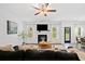 Bright living room with a fireplace, large TV, and an elegant ceiling fan at 3360 Meadow Grass Dr, Dacula, GA 30019
