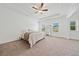 Main bedroom with tray ceilings, carpeted floors, a ceiling fan and multiple windows at 3360 Meadow Grass Dr, Dacula, GA 30019