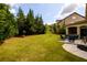 Spacious backyard with lush lawn, mature trees, and a patio seating area at 6110 Read Rd, Suwanee, GA 30024