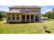 Expansive backyard featuring a covered porch, outdoor seating, and lush green lawn at 6110 Read Rd, Suwanee, GA 30024