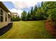 Green backyard featuring well-maintained lawn, and mature trees, creating a serene outdoor space at 6110 Read Rd, Suwanee, GA 30024
