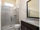 Bathroom with granite countertop, dark wood cabinet, and a glass-enclosed shower at 6110 Read Rd, Suwanee, GA 30024