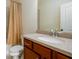 Well-lit bathroom featuring a shower and tub combination with neutral tile, light countertops and wood cabinetry at 6110 Read Rd, Suwanee, GA 30024