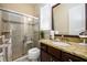 Accessible bathroom with granite countertop, dark wood cabinet, and a glass-enclosed shower with a seat at 6110 Read Rd, Suwanee, GA 30024