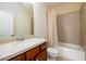 Well-lit bathroom featuring a shower and tub combination with neutral tile, light countertops and wood cabinetry at 6110 Read Rd, Suwanee, GA 30024
