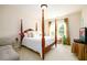 Well-lit bedroom with a four poster bed, natural light and sitting area; perfect for relaxing at 6110 Read Rd, Suwanee, GA 30024