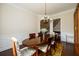 Dining area with wooden table, patterned chairs, and view to entry and staircase at 6110 Read Rd, Suwanee, GA 30024