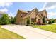 Stately brick home with manicured front lawn, long driveway, and three-car garage at 6110 Read Rd, Suwanee, GA 30024