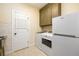 Modern laundry room with tiled floor, custom cabinets, laundry sink, washer, dryer and a refrigerator at 6110 Read Rd, Suwanee, GA 30024