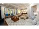 Living room with natural light, hardwood floors, coffered ceiling, and access to an outdoor deck at 6110 Read Rd, Suwanee, GA 30024