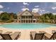 View of the community pool with lounge chairs and a beautiful clubhouse at 6110 Read Rd, Suwanee, GA 30024