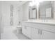 Modern bathroom with double vanity, white cabinets, and tub with stylish tile at 4087 Kingsley Park Ct, Peachtree Corners, GA 30096