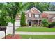 Charming two-story brick home with black shutters, a well-manicured lawn, and a two-car garage at 4087 Kingsley Park Ct, Peachtree Corners, GA 30096