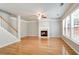 Open living room featuring hardwood floors, a fireplace, a ceiling fan, and large windows at 4087 Kingsley Park Ct, Peachtree Corners, GA 30096