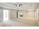 Large main bedroom showcasing a tray ceiling, fan, and doors to bathroom and closet at 4087 Kingsley Park Ct, Peachtree Corners, GA 30096