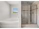 Modern bathroom featuring a soaking tub and a separate tiled shower with a glass door at 6660 Country Lake Rd, Cumming, GA 30041