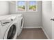 Well-lit laundry room featuring a washer and dryer, neutral paint, and tiled floor at 6660 Country Lake Rd, Cumming, GA 30041