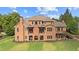 Brick home with a large backyard, multiple balconies, and outdoor living spaces at 13037 Overlook Pass, Roswell, GA 30075