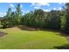 Large, well-maintained backyard featuring lush green grass and mature trees on a sunny day at 13037 Overlook Pass, Roswell, GA 30075