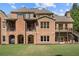 Expansive brick home featuring a spacious backyard and charming balconies on the upper level at 13037 Overlook Pass, Roswell, GA 30075