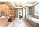 Luxurious bathroom featuring granite counters, custom cabinetry, tile floors, and soaking tub at 13037 Overlook Pass, Roswell, GA 30075