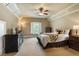 This neutral bedroom features a tray ceiling, ceiling fan, and large window with natural light at 13037 Overlook Pass, Roswell, GA 30075