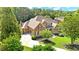 Stately brick home featuring a lush green lawn, mature trees, and an inviting circular driveway at 13037 Overlook Pass, Roswell, GA 30075