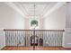 Open foyer with detailed railing overlooking the front door and chandelier at 13037 Overlook Pass, Roswell, GA 30075