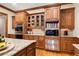 Custom kitchen featuring wood cabinets, granite countertops, tile backsplash, and built-in microwave at 13037 Overlook Pass, Roswell, GA 30075