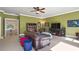 Well-lit bonus room with a green paint, ceiling fan, seating area, and TV at 13037 Overlook Pass, Roswell, GA 30075