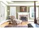 Elegant bedroom featuring a cozy chair by the fireplace, large windows, and hardwood floors at 13037 Overlook Pass, Roswell, GA 30075
