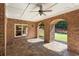 Covered outdoor patio with brick columns, stone flooring, and access to the backyard at 13037 Overlook Pass, Roswell, GA 30075