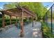 Outdoor pergola with seating area and lush landscaping, providing a relaxing space for dining and entertaining at 13037 Overlook Pass, Roswell, GA 30075