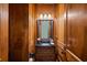 Elegant powder room featuring wood paneling, black granite countertop, and unique fixtures at 13037 Overlook Pass, Roswell, GA 30075