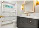 Bathroom featuring glass shower, gray vanity, and brushed gold fixtures at 375 Chattahoochee St, Roswell, GA 30075