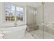 Bright bathroom featuring a soaking tub near window and modern shower with glass enclosure at 375 Chattahoochee St, Roswell, GA 30075