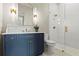 Stylish bathroom featuring a blue vanity with marble countertop, modern lighting, and glass-enclosed shower at 375 Chattahoochee St, Roswell, GA 30075