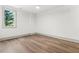 Bright bedroom showcasing modern flooring and natural light from the single window at 375 Chattahoochee St, Roswell, GA 30075