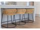 Close-up of kitchen island with marble countertop and three woven stools at 375 Chattahoochee St, Roswell, GA 30075