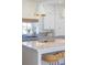 Close-up of kitchen island with marble countertop, gold faucet, and woven stools at 375 Chattahoochee St, Roswell, GA 30075