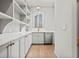 Charming pantry with white cabinets, open shelving, and a sink under the window at 375 Chattahoochee St, Roswell, GA 30075
