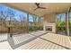 Covered outdoor patio featuring a stone fireplace, wood flooring, and natural views at 375 Chattahoochee St, Roswell, GA 30075
