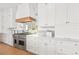 Gourmet kitchen features a stainless steel stove, wood trim hood, and marble countertops at 375 Chattahoochee St, Roswell, GA 30075