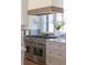 Close-up of the stainless steel stove, wood trim hood, and marble backsplash at 375 Chattahoochee St, Roswell, GA 30075