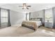 Spacious primary bedroom featuring tray ceilings, soft carpet, and natural light from two large windows at 1037 Panoramic Pte, Buford, GA 30518