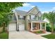 Charming two-story home with brick accents, covered porch, manicured lawn, and a two-car garage at 1037 Panoramic Pte, Buford, GA 30518