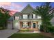 Charming two-story home with brick accents, covered porch and manicured lawn, at sunset at 1037 Panoramic Pte, Buford, GA 30518