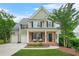 Charming two-story home with brick accents, covered porch, manicured lawn, and a two-car garage at 1037 Panoramic Pte, Buford, GA 30518